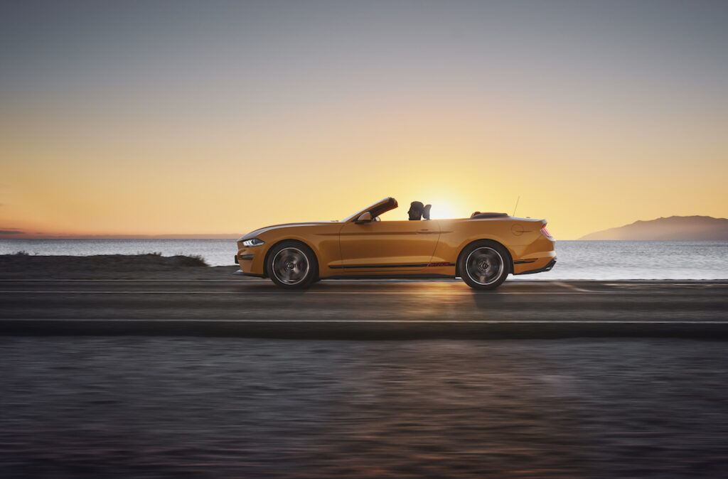 Ford Mustang am Starnd mit der Sonne im Hintergrund